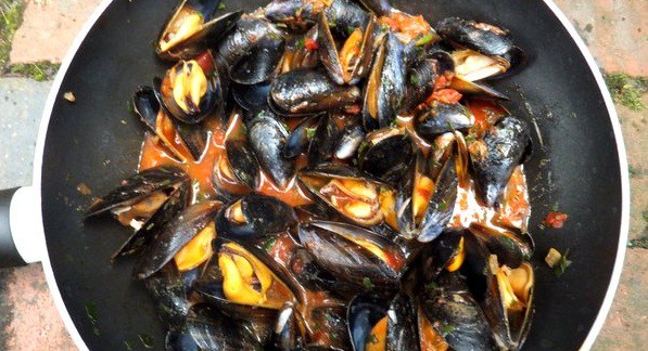 mussels with buttery turmeric broth in a saucepan